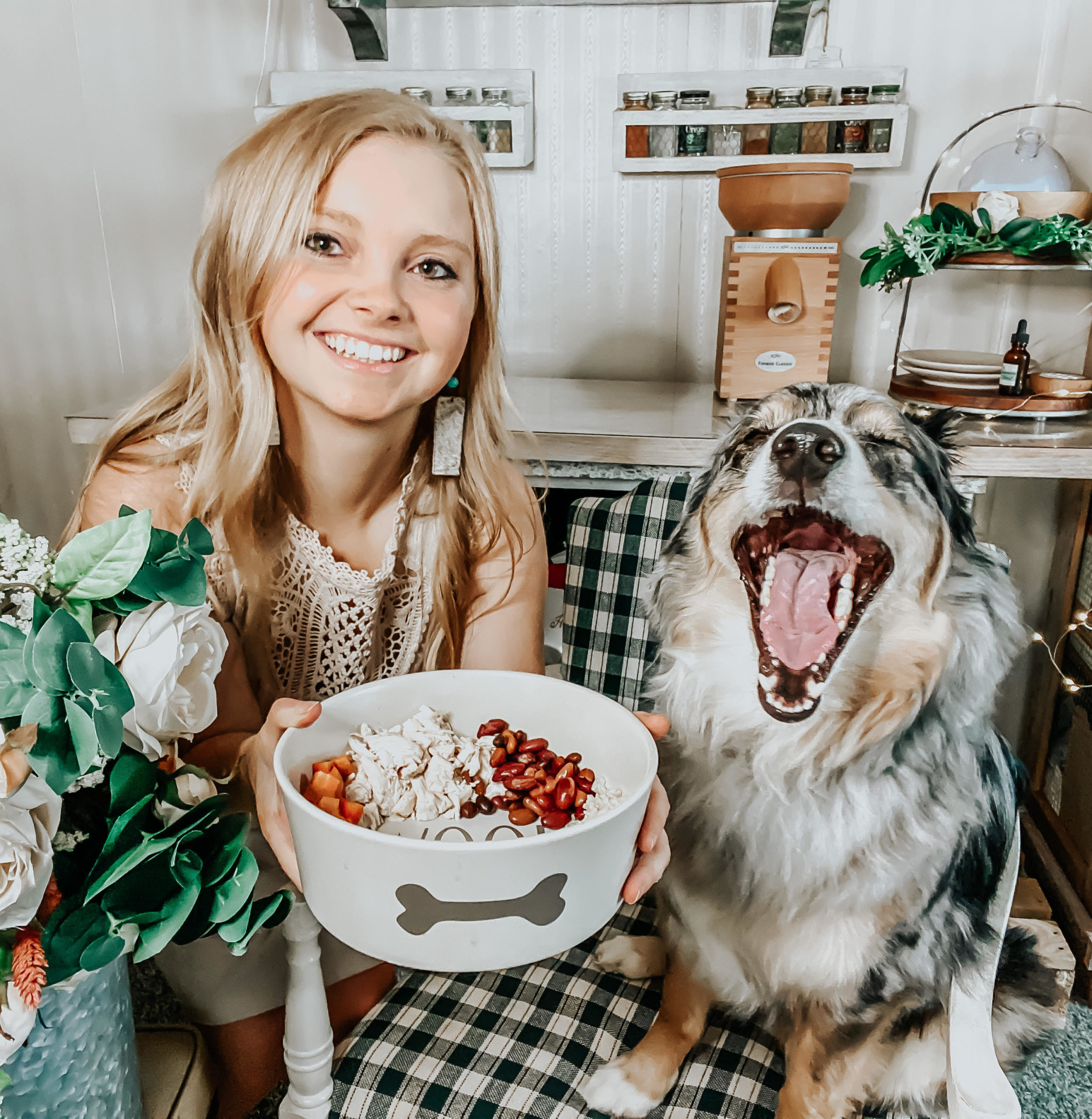 australian shepherd dog with mouth wide open like she is screaming with a blonde girl (kiersten zile) holding a bowl of homemade dog food