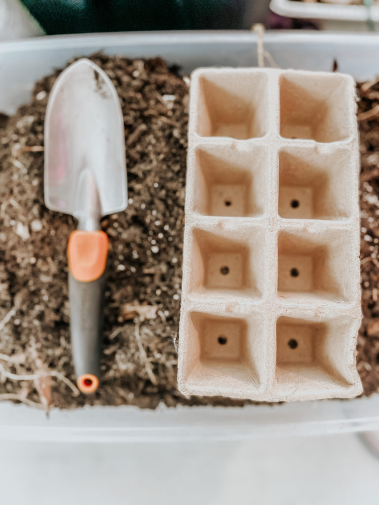 brown seed trays next to a garden shovel for germinating seeds quickly