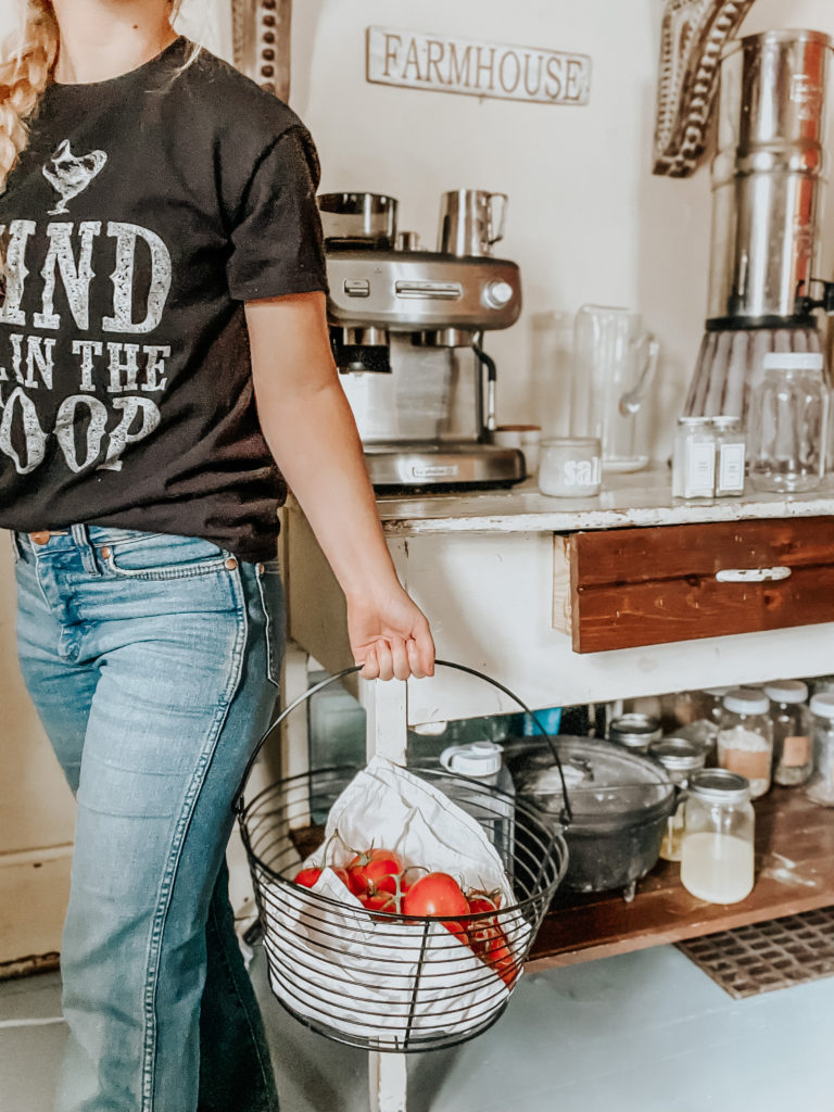 kiersten zile holding a harvest of tomatos to ferment tomatos for preserving