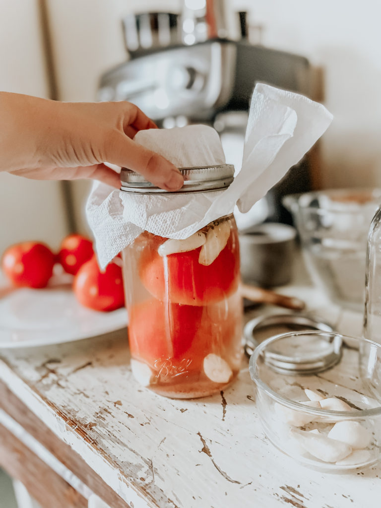 kiersten zile holding a jar of fermented tomatoes 