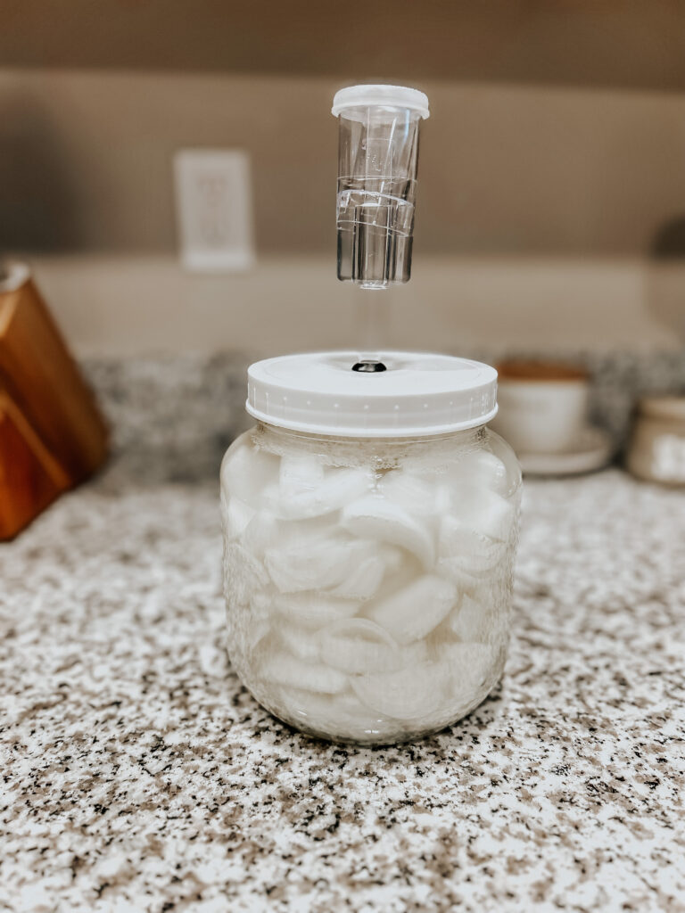 lacto fermented onions in an airlock container